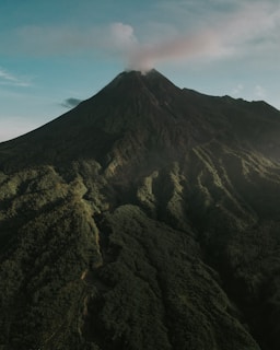 a very tall mountain with a cloud in the sky