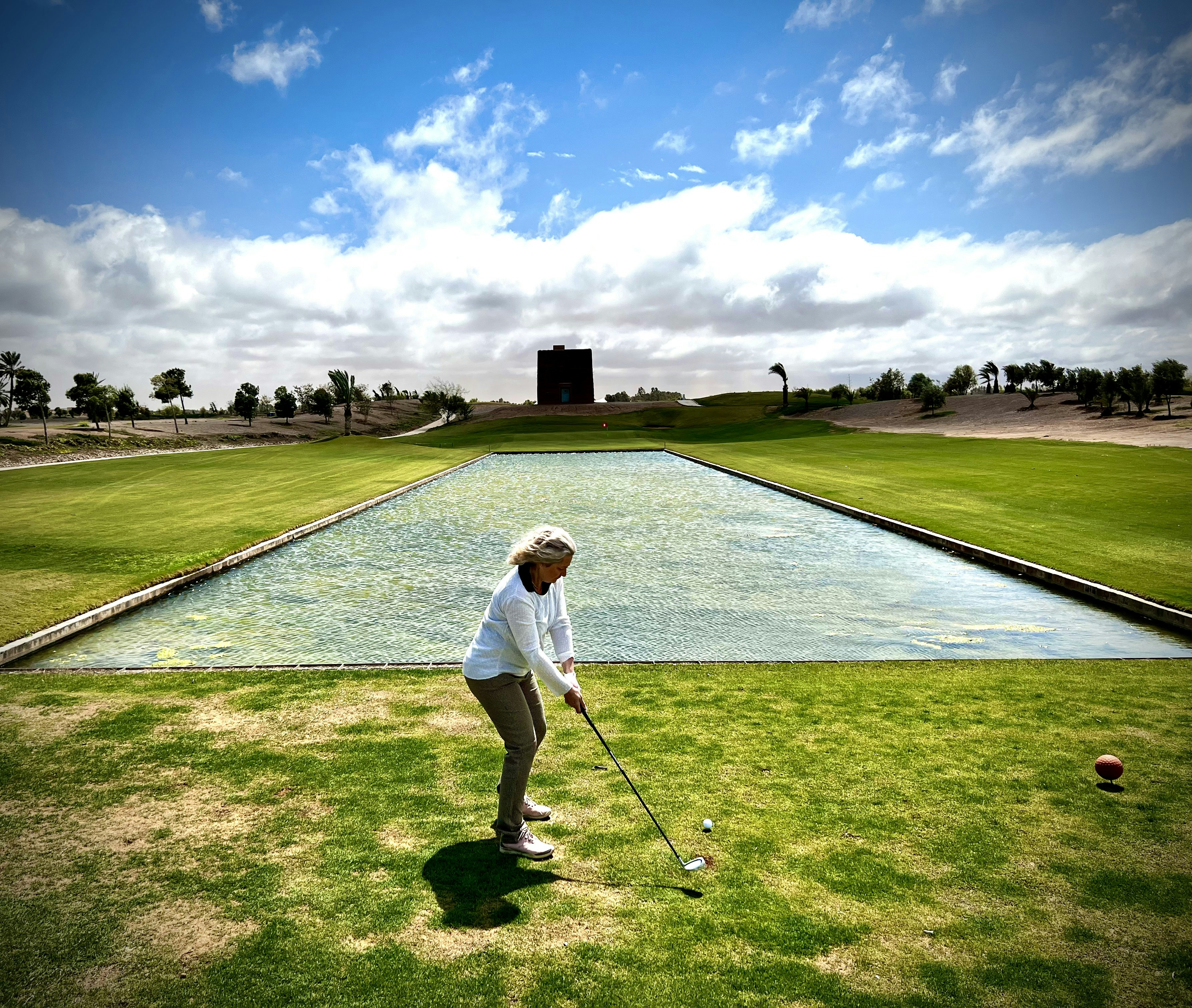 Fotomural a woman in a white shirt is playing golf