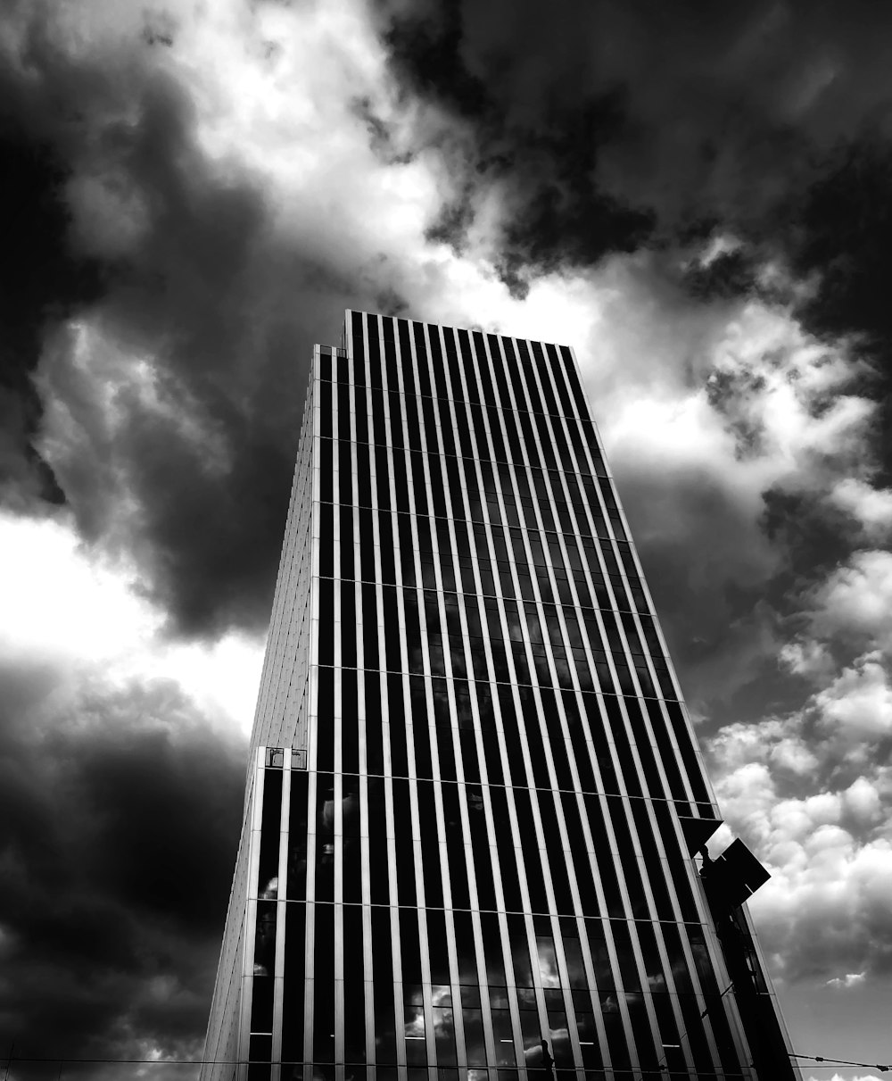 a very tall building with a lot of clouds in the background