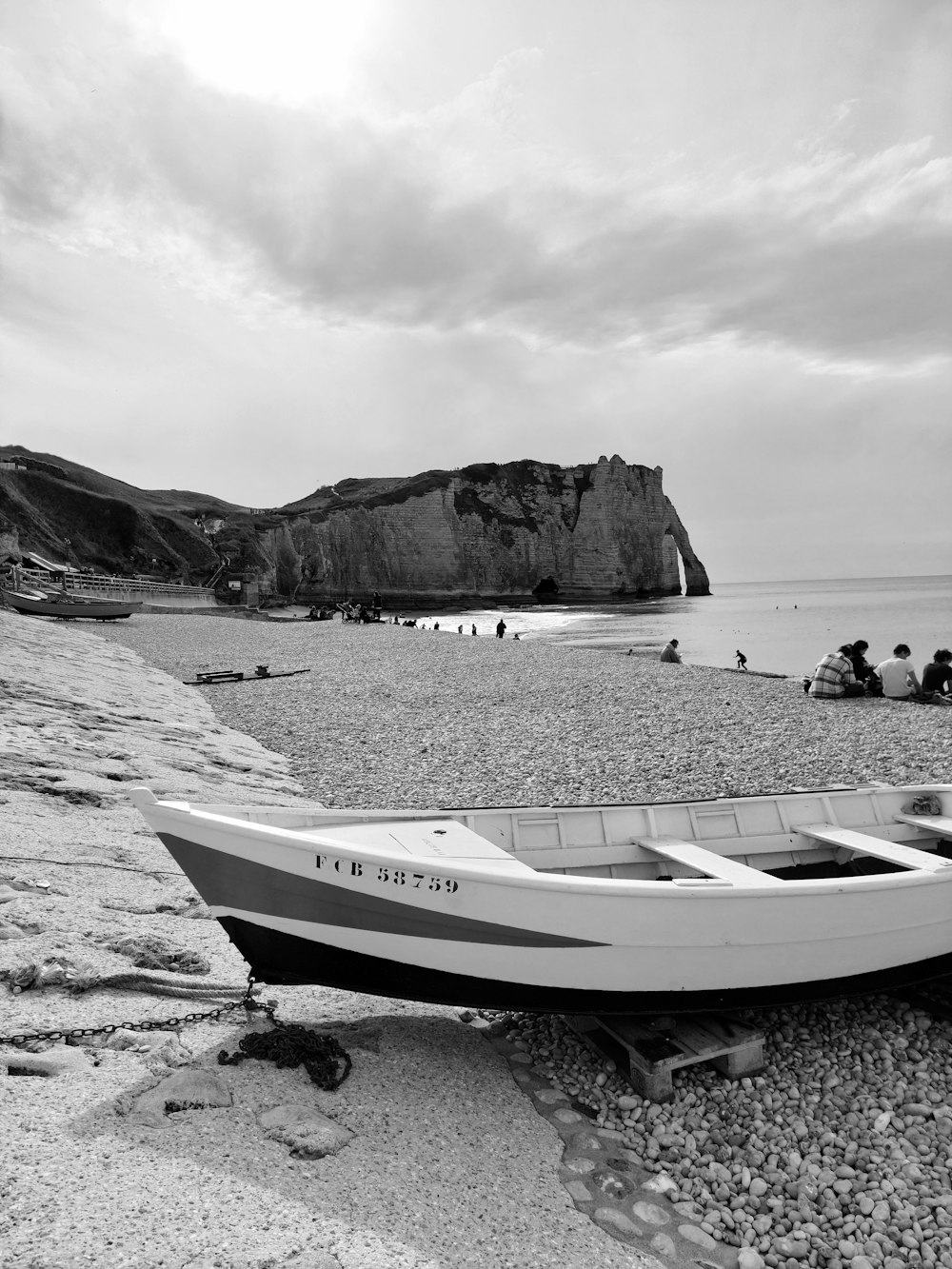 a boat on the beach with people on the shore