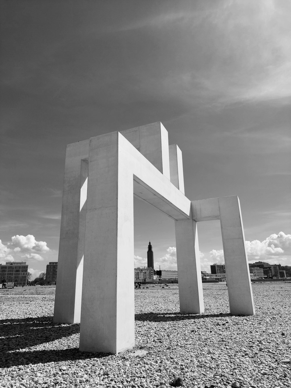 a large white sculpture sitting on top of a gravel field