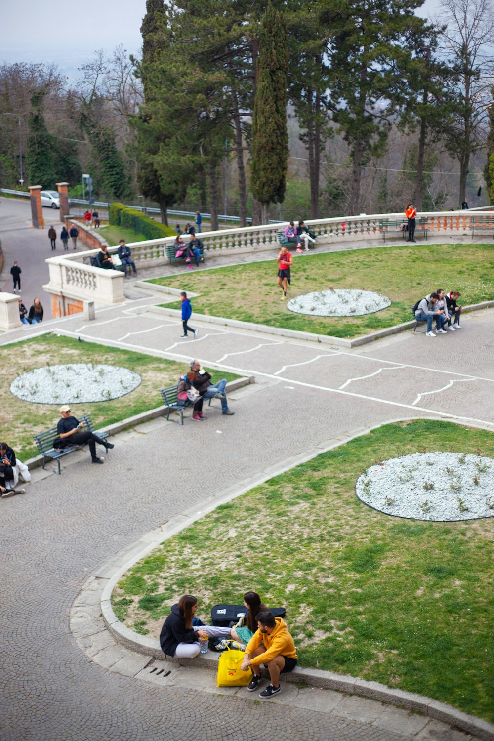 a group of people sitting on top of a lush green park