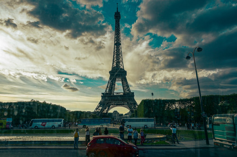 a red car parked in front of the eiffel tower