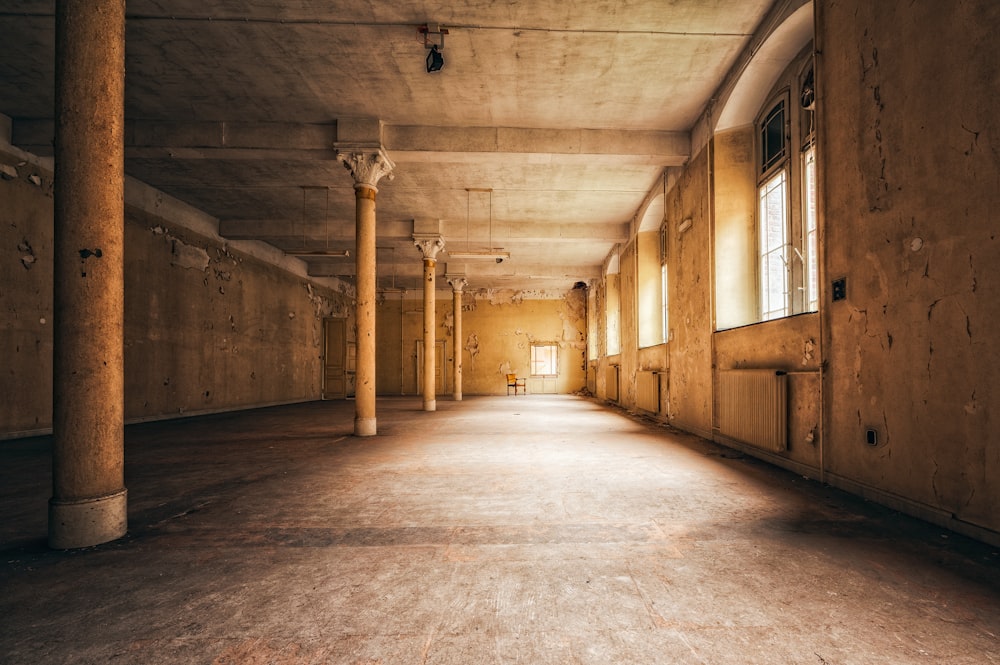 an empty room with columns and a window