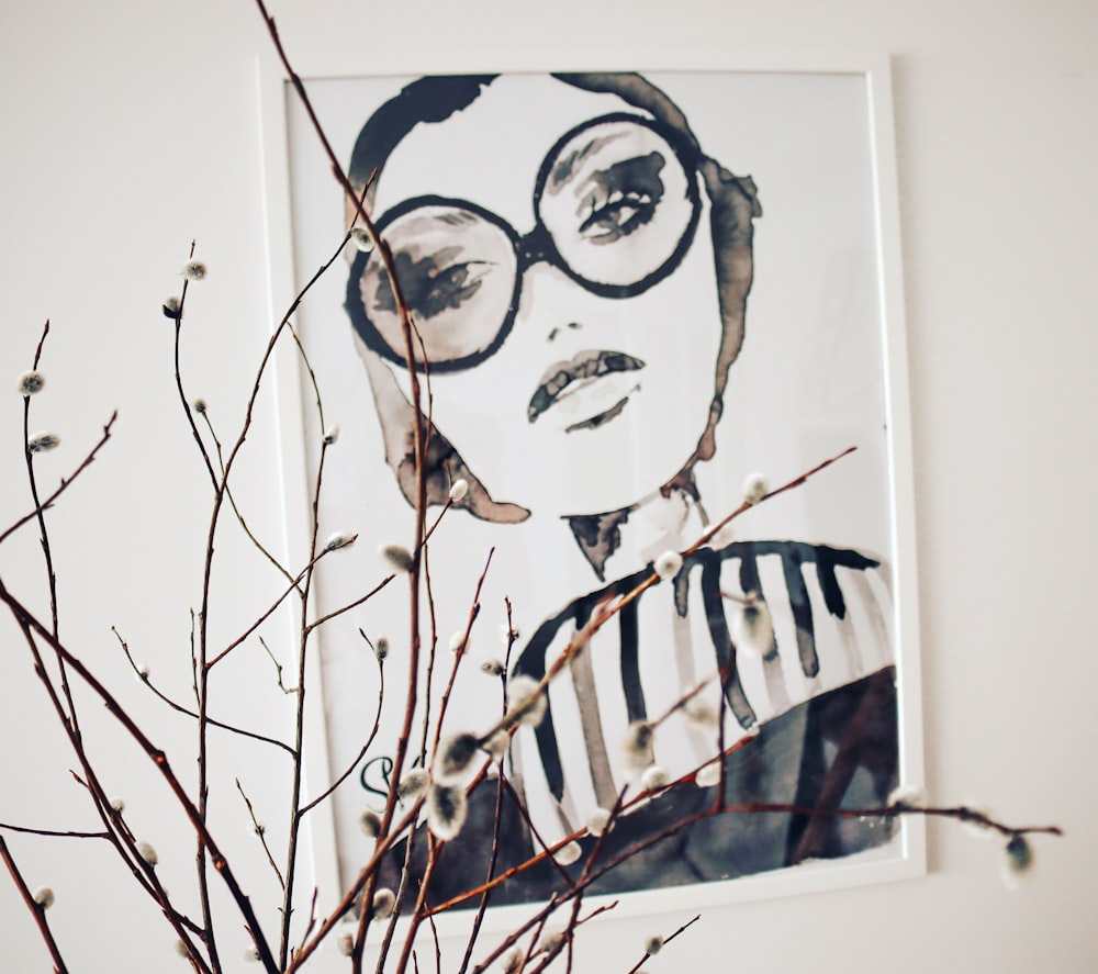 a picture of a woman with glasses and a branch