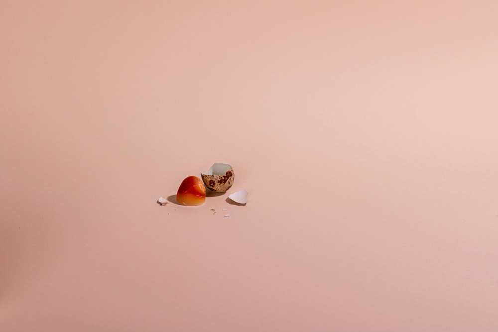 a couple of pieces of fruit floating on top of a pink surface