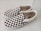 A pair of slip-on shoes with a classic black and white checkerboard pattern on the fabric. The shoes have white rubber soles and visible branding on the inner sole and side tags. They are positioned side by side on a light-colored surface.