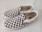 A pair of slip-on shoes with a classic black and white checkerboard pattern on the fabric. The shoes have white rubber soles and visible branding on the inner sole and side tags. They are positioned side by side on a light-colored surface.