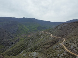 A serene mountain trail winding through lush green forest in Villa Yacanto.