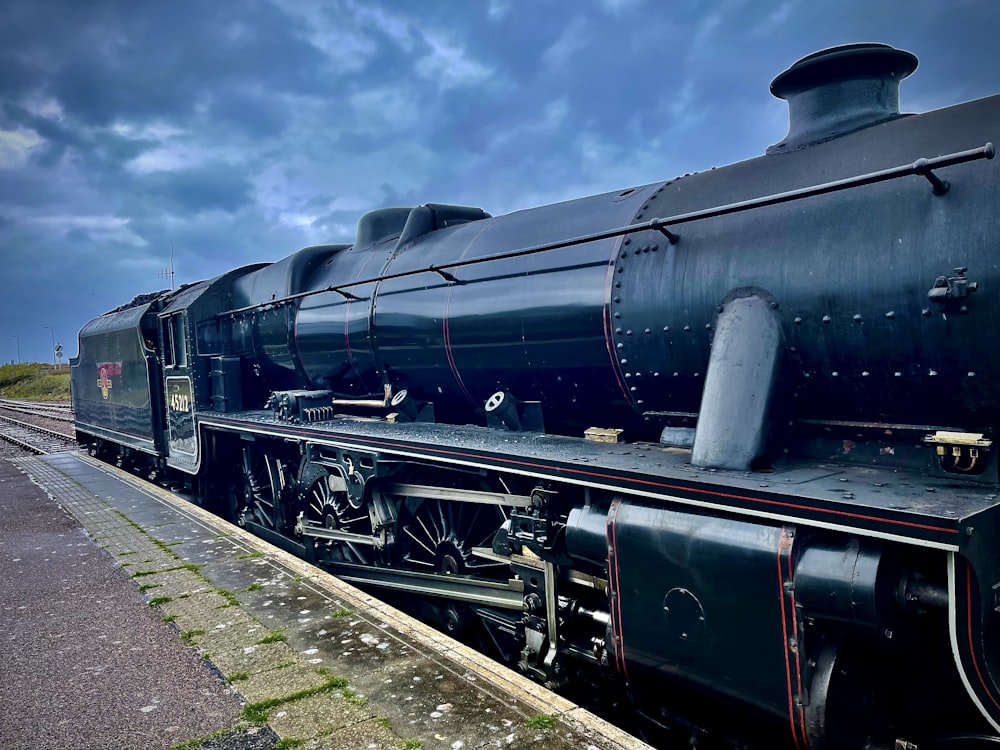 a black train engine sitting on the tracks