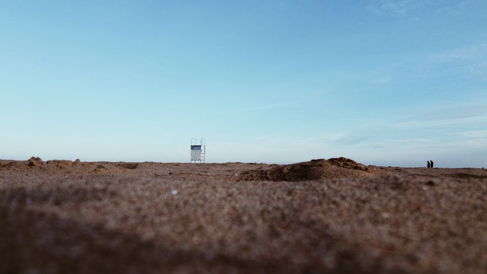 a dirt field with a sign in the distance