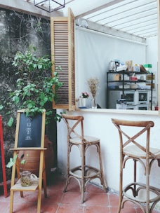 a couple of wooden chairs sitting next to a window