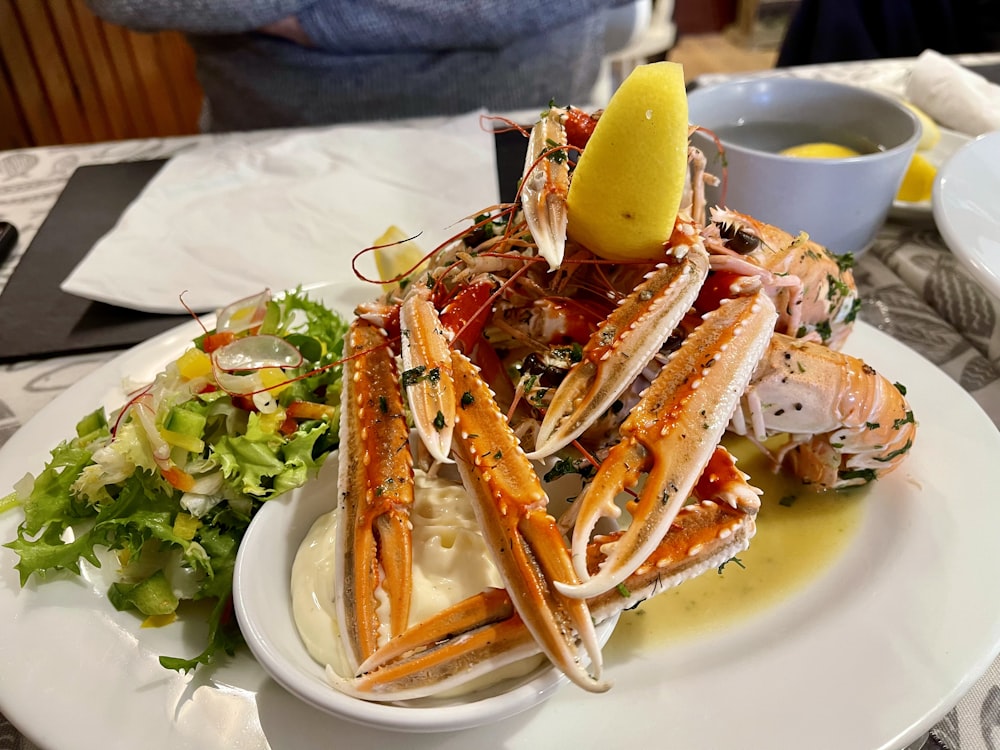 a white plate topped with a pile of crab legs