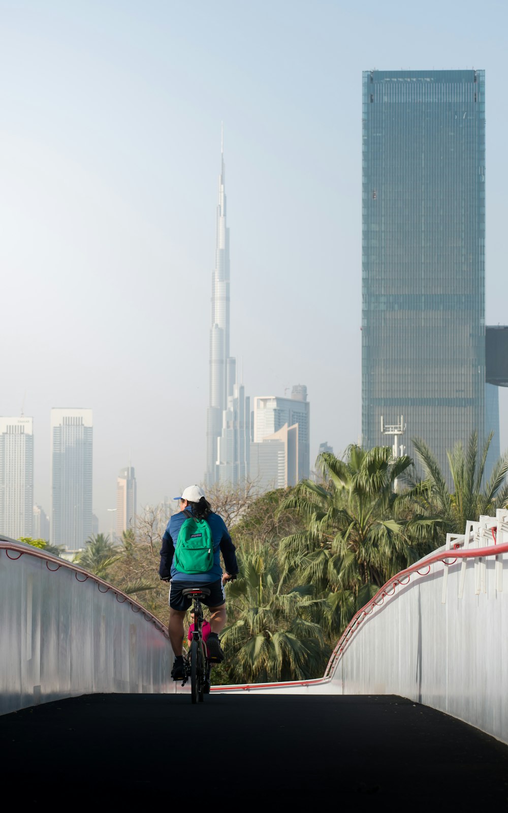 a person riding a bike on a bridge with a city in the background