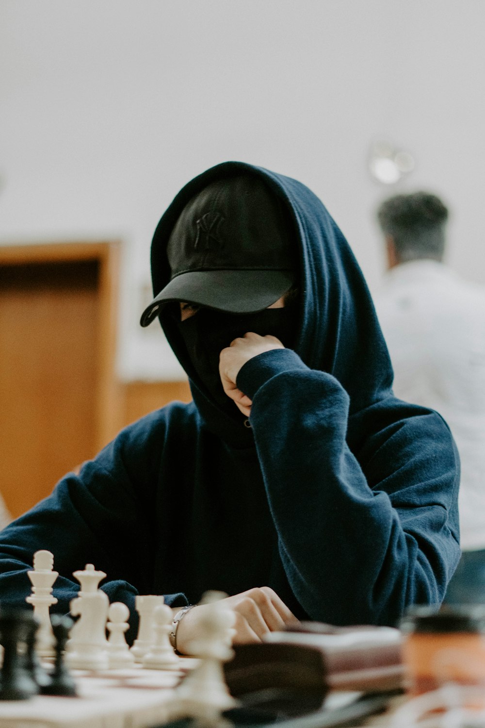 a person wearing a hood playing chess