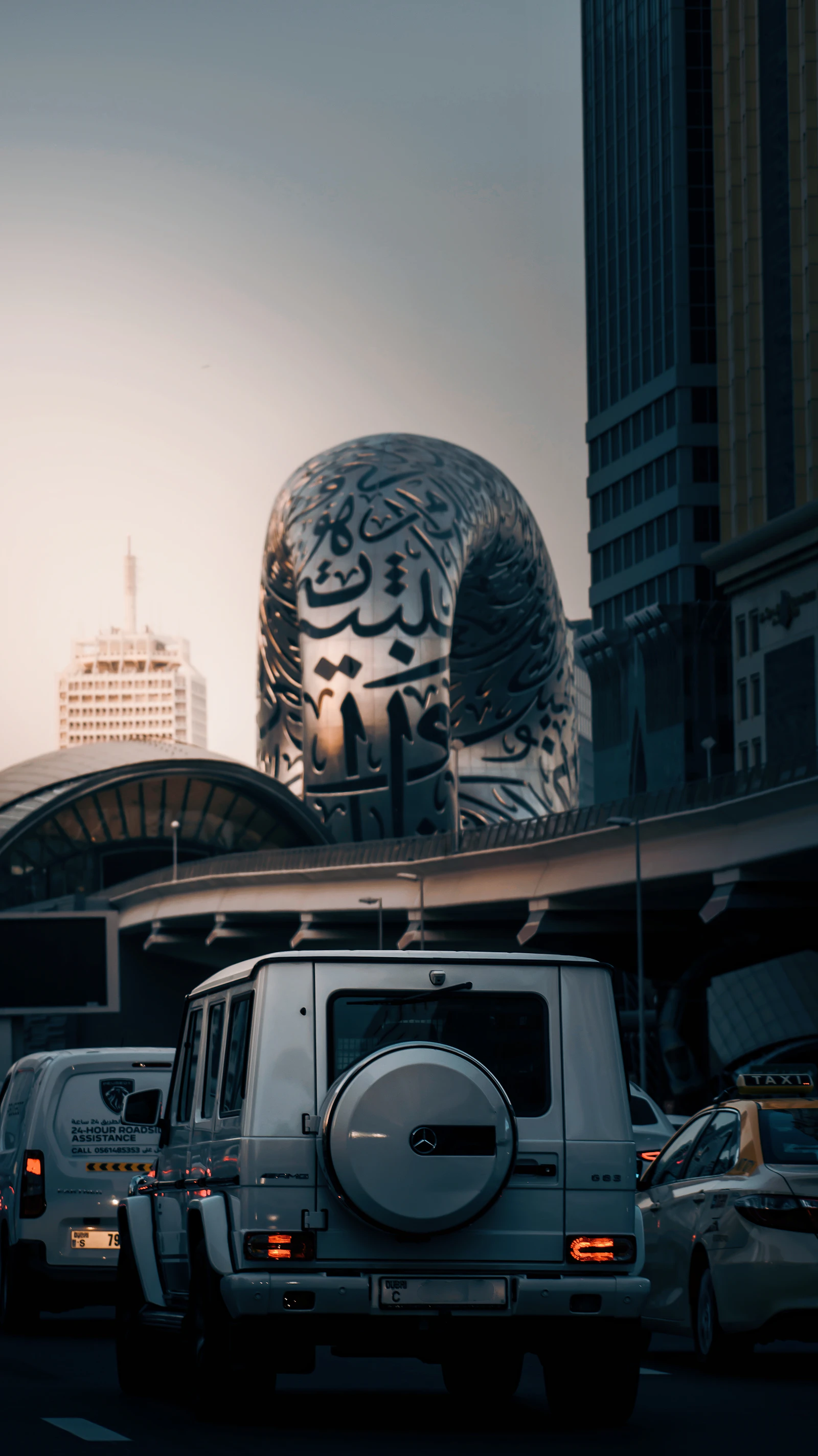 A truck driving down a Dubai street beside tall buildings