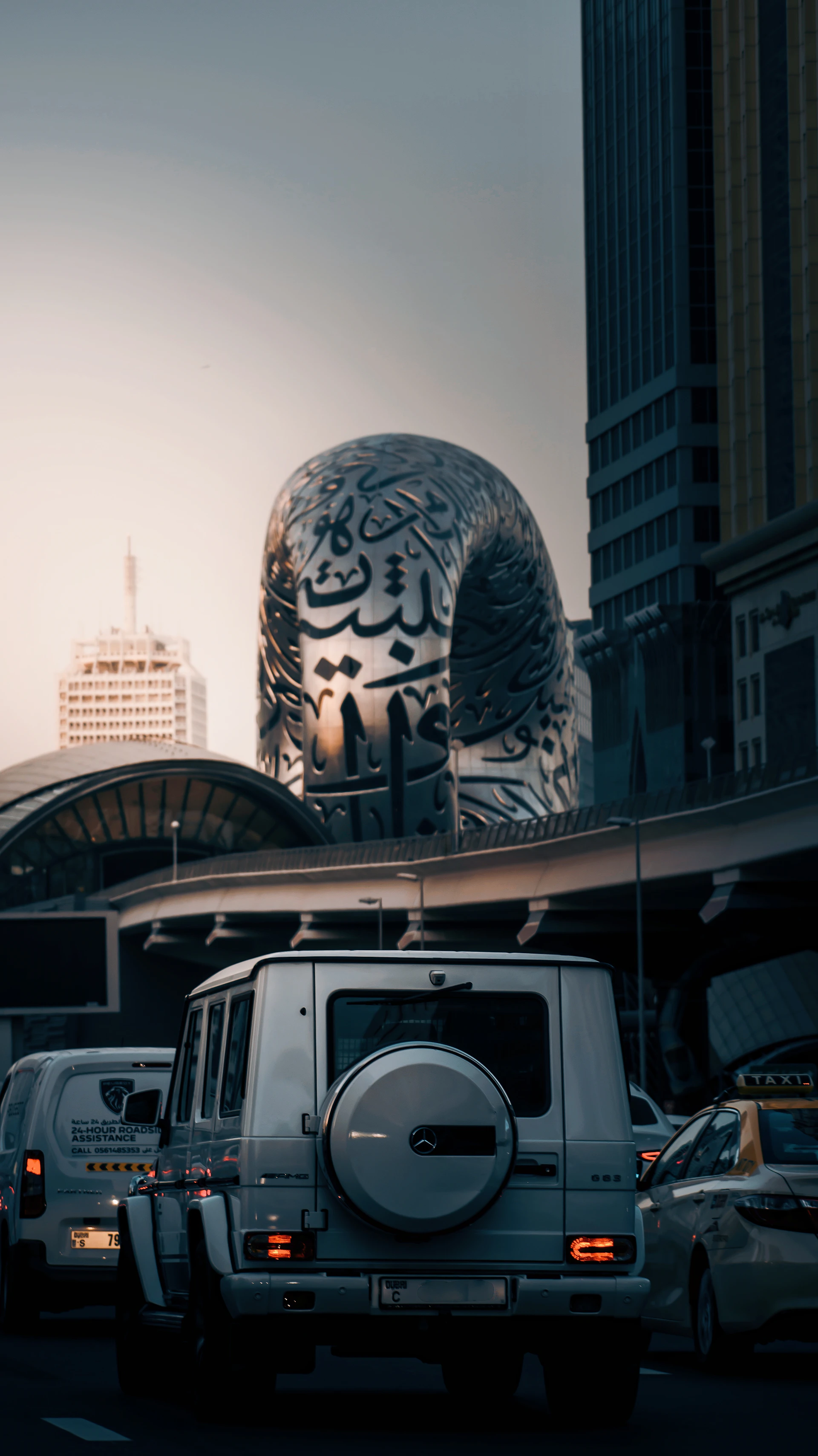a truck driving down a street next to tall buildings