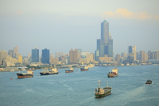 A dynamic skyline of Lagos with bustling trade ships in the harbor at sunset.