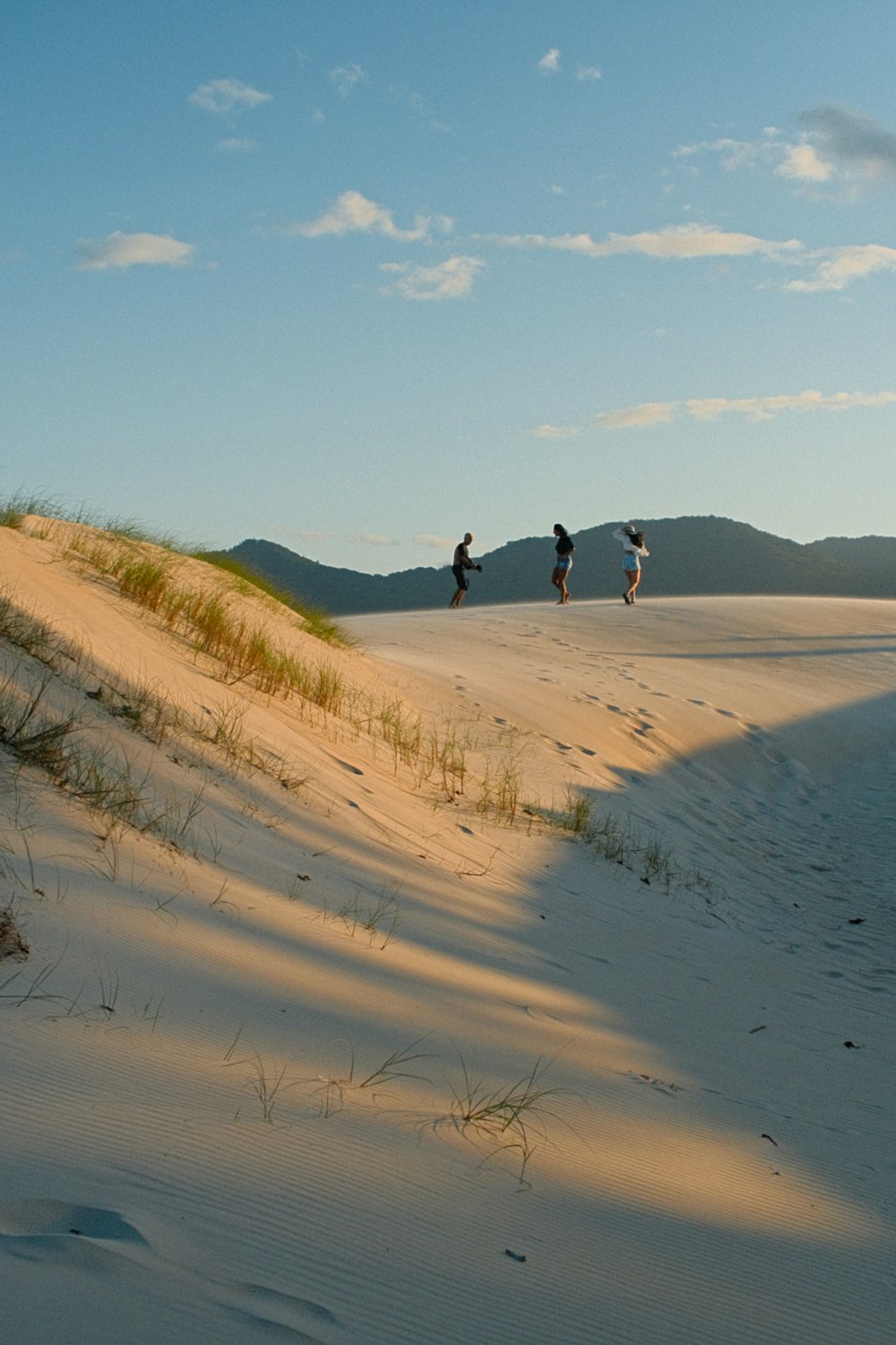 a group of people walking across a sandy beach