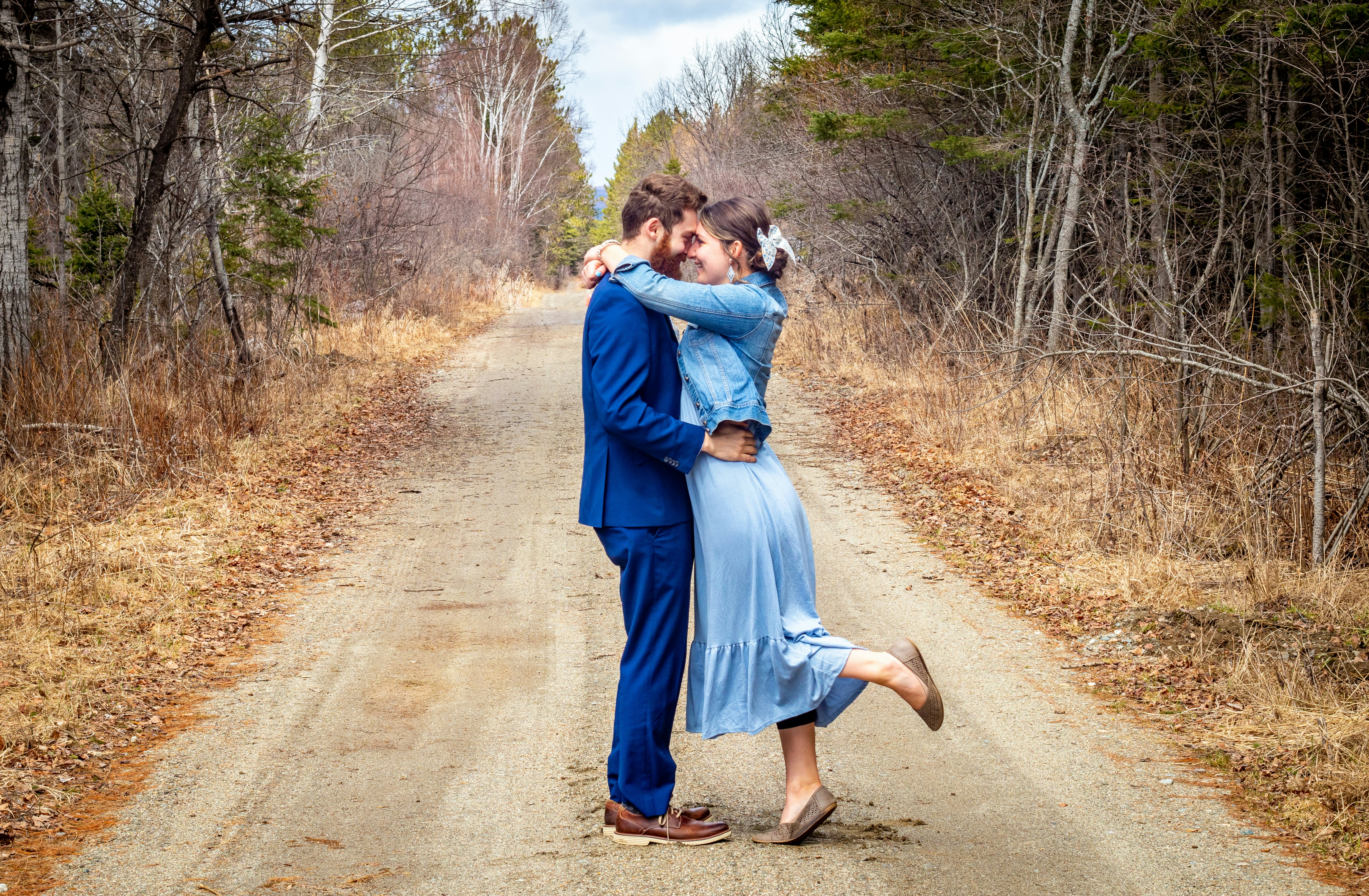 um homem e uma mulher se beijando em uma estrada de terra