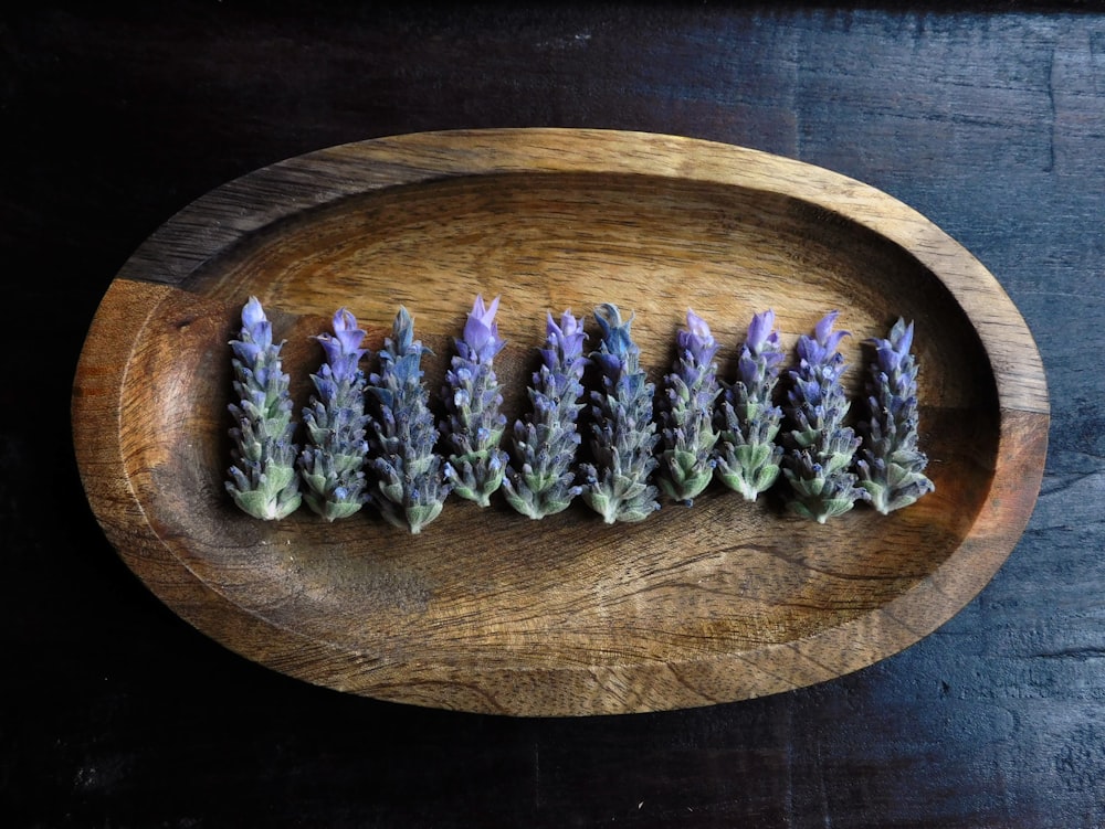 a bunch of lavender flowers sitting on top of a wooden plate