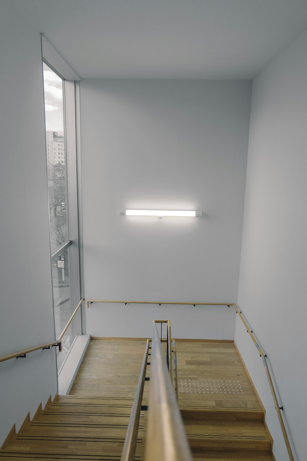 uma sala vazia com escadas de madeira e uma janela