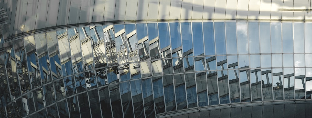 the reflection of a clock in the glass of a building