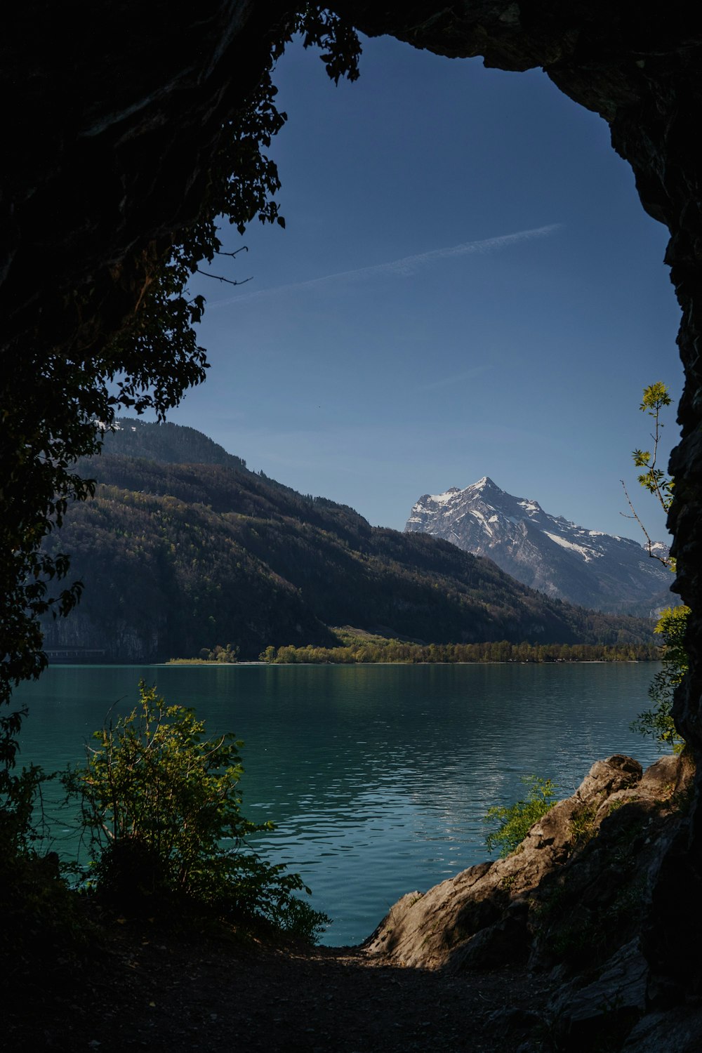 a view of a mountain lake through a cave