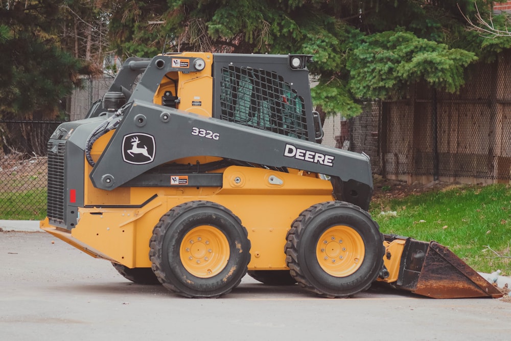 a yellow and black skid steer parked in a parking lot