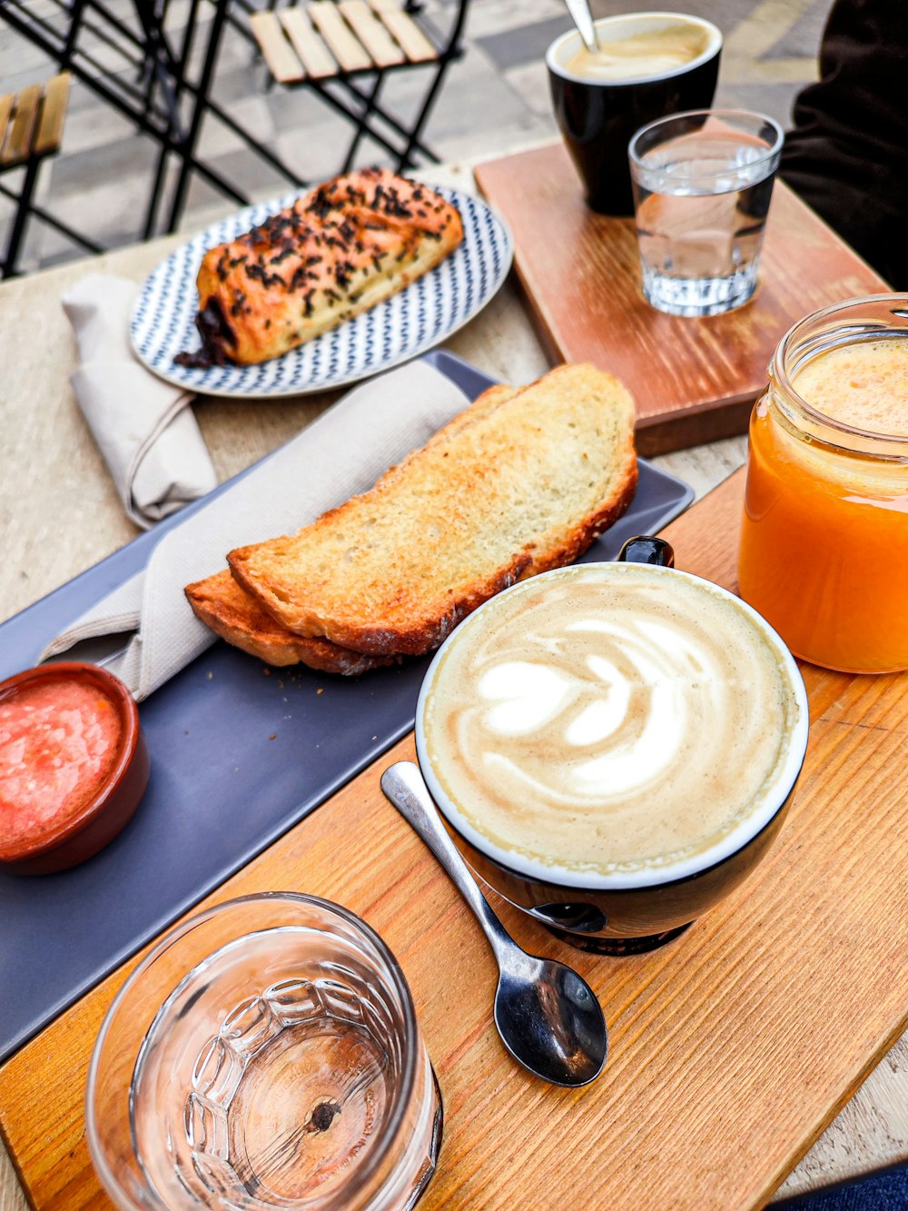 a wooden table topped with plates of food and drinks