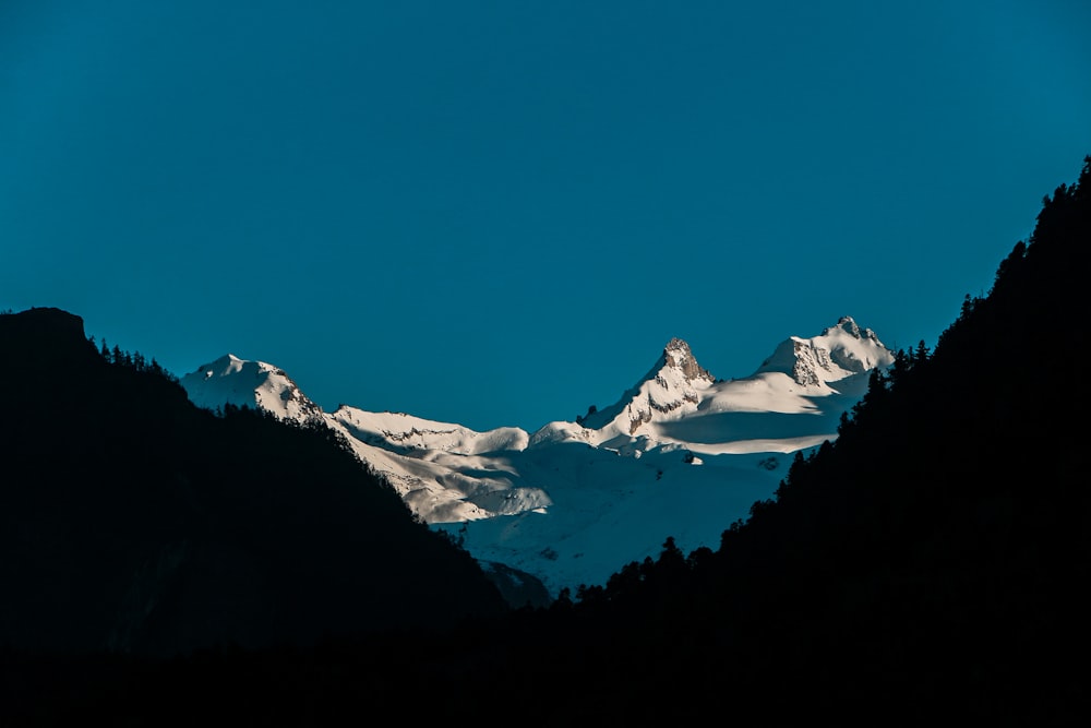 a mountain range with snow covered mountains in the background