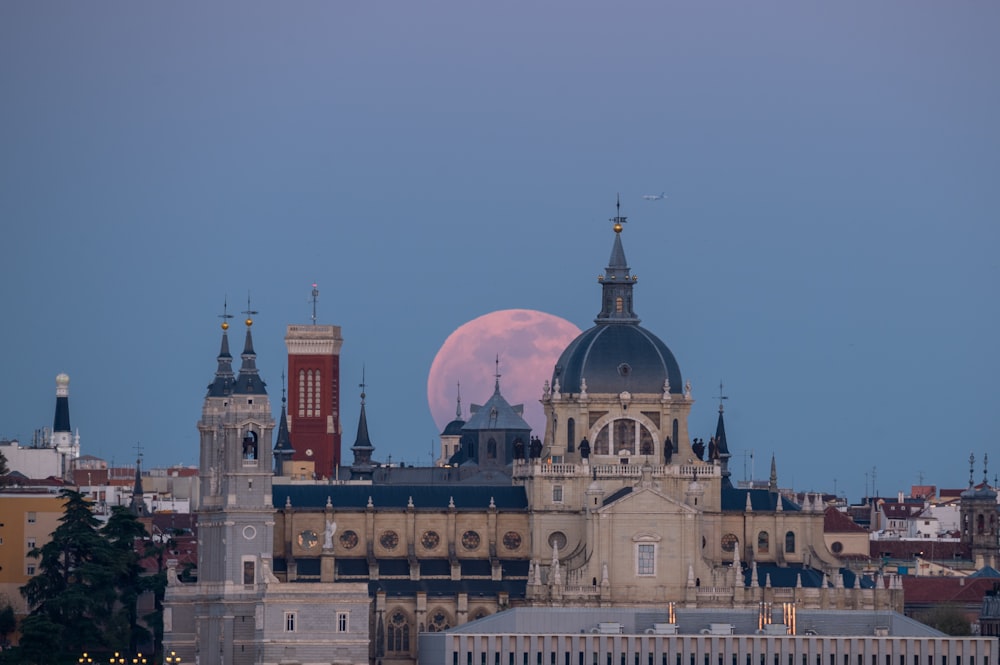 a full moon rises over a city skyline