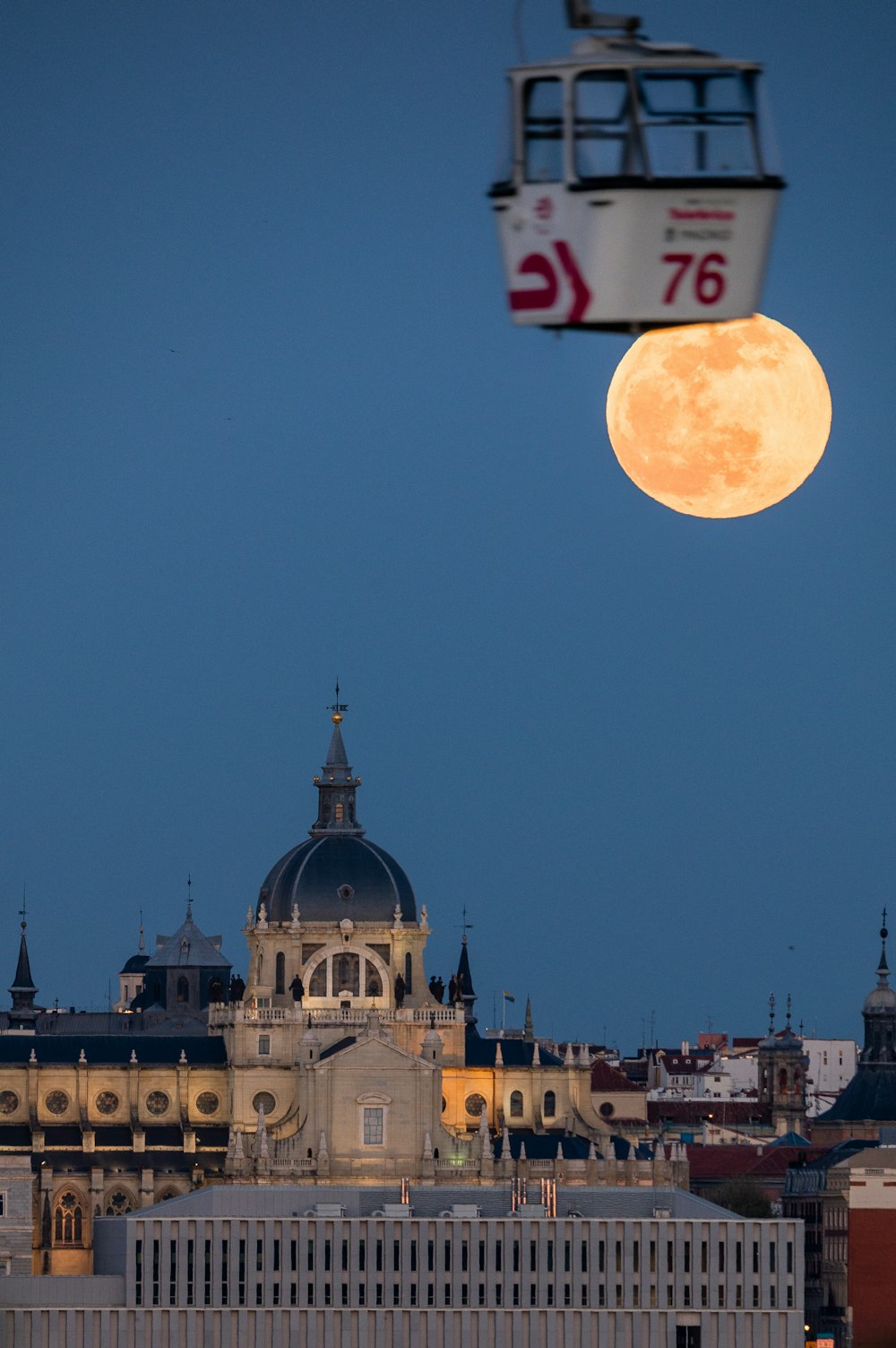 a full moon is seen over a city