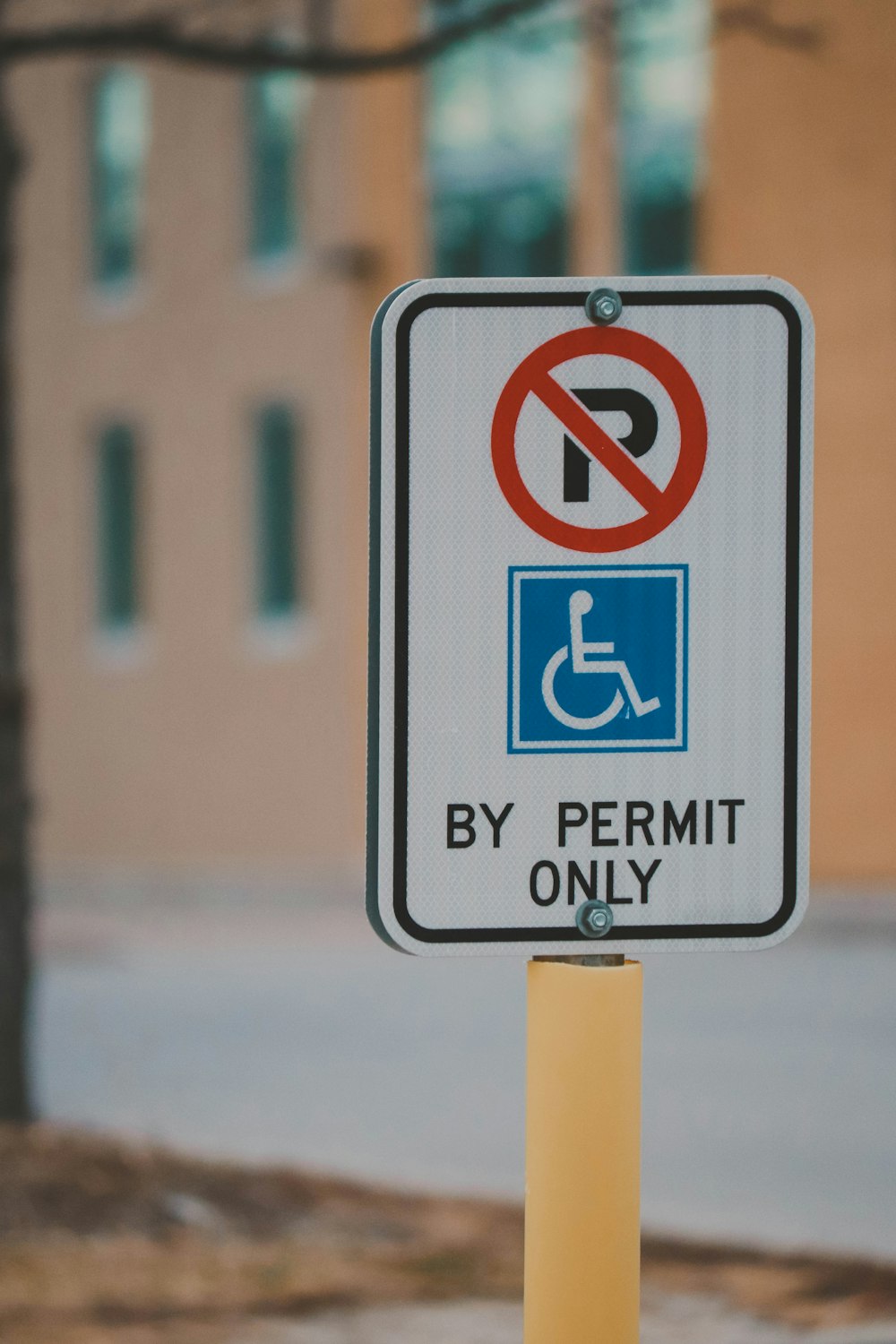 una señal de no estacionamiento en un poste frente a un edificio