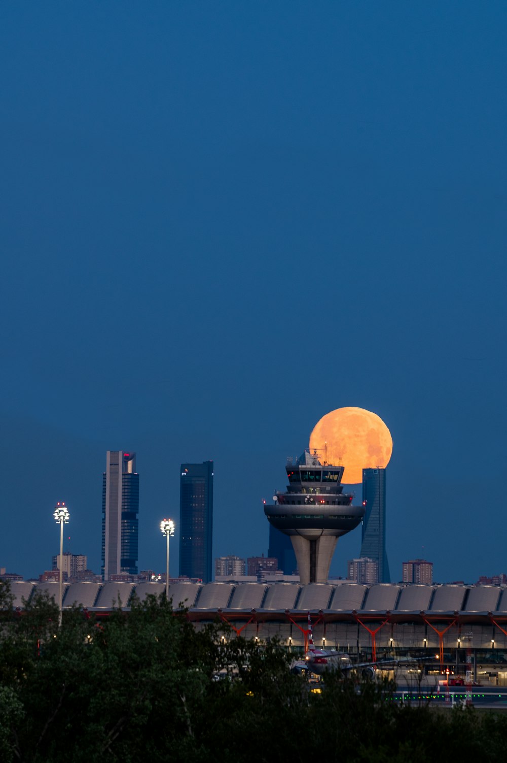 Une pleine lune se lève sur les toits d’une ville