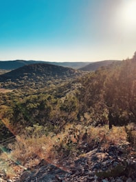 the sun shines brightly over a mountain valley