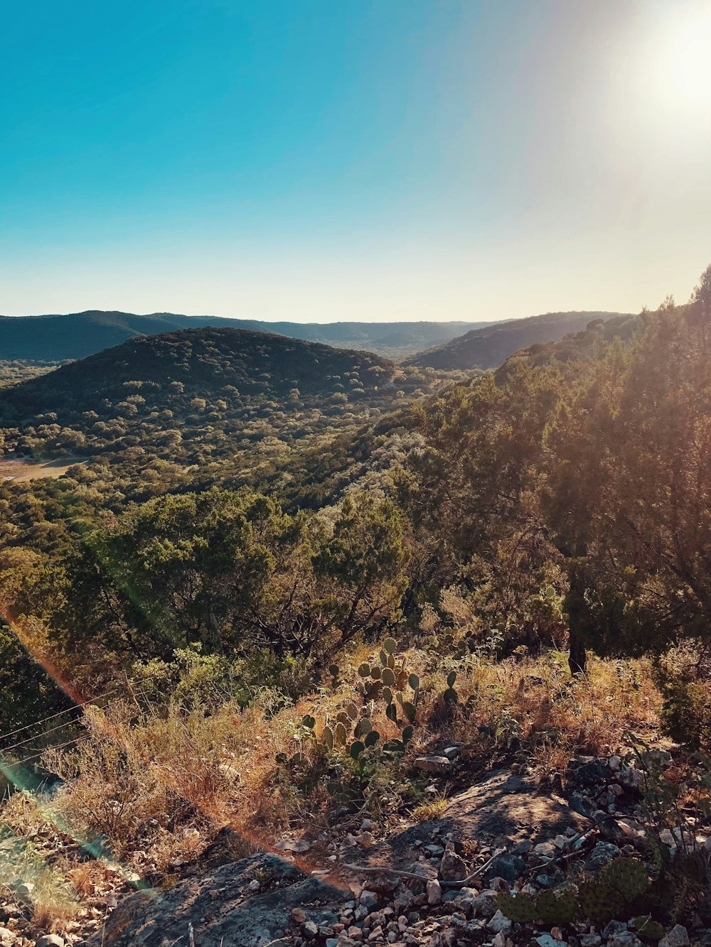 the sun shines brightly over a mountain valley