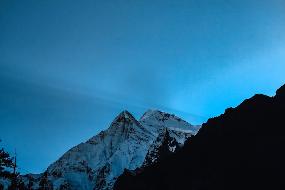 Una montagna innevata con un cielo blu sullo sfondo