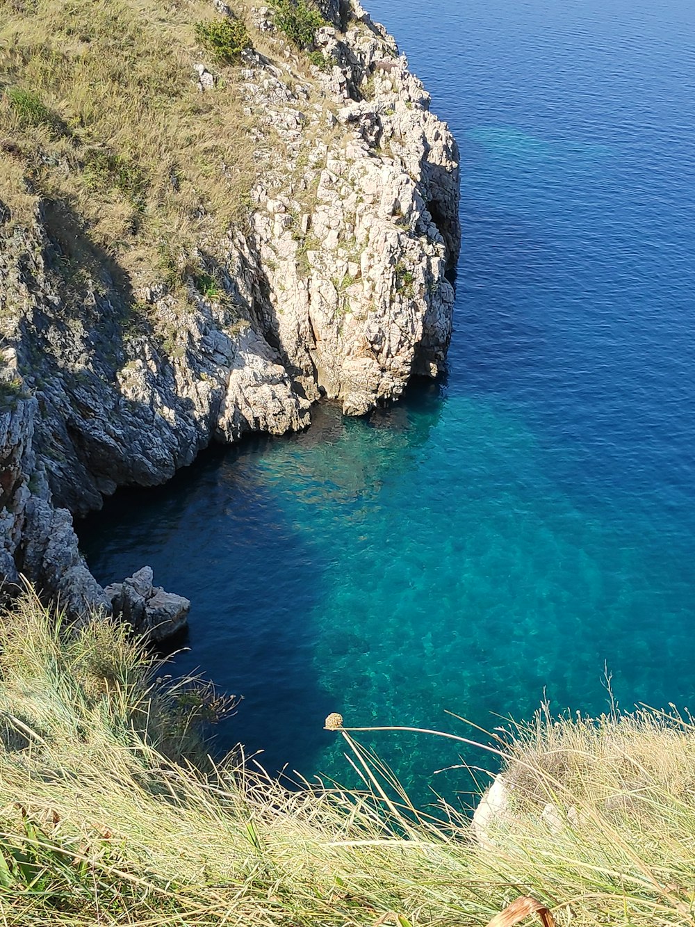 a body of water surrounded by a rocky cliff