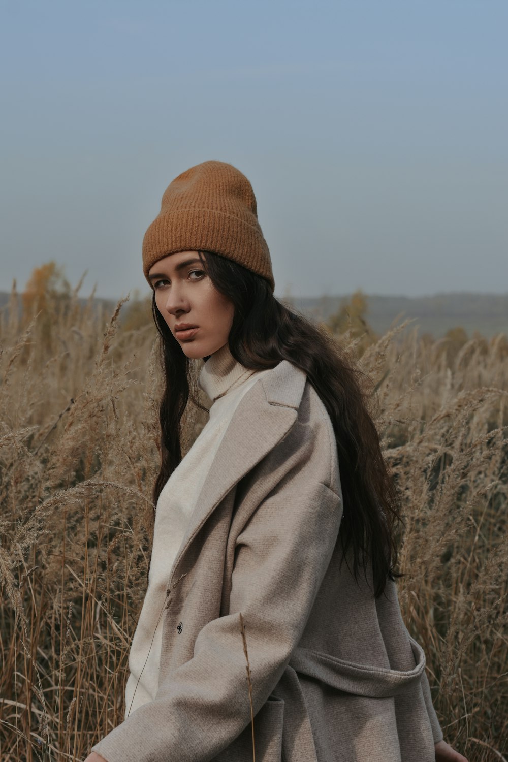 a woman standing in a field of tall grass