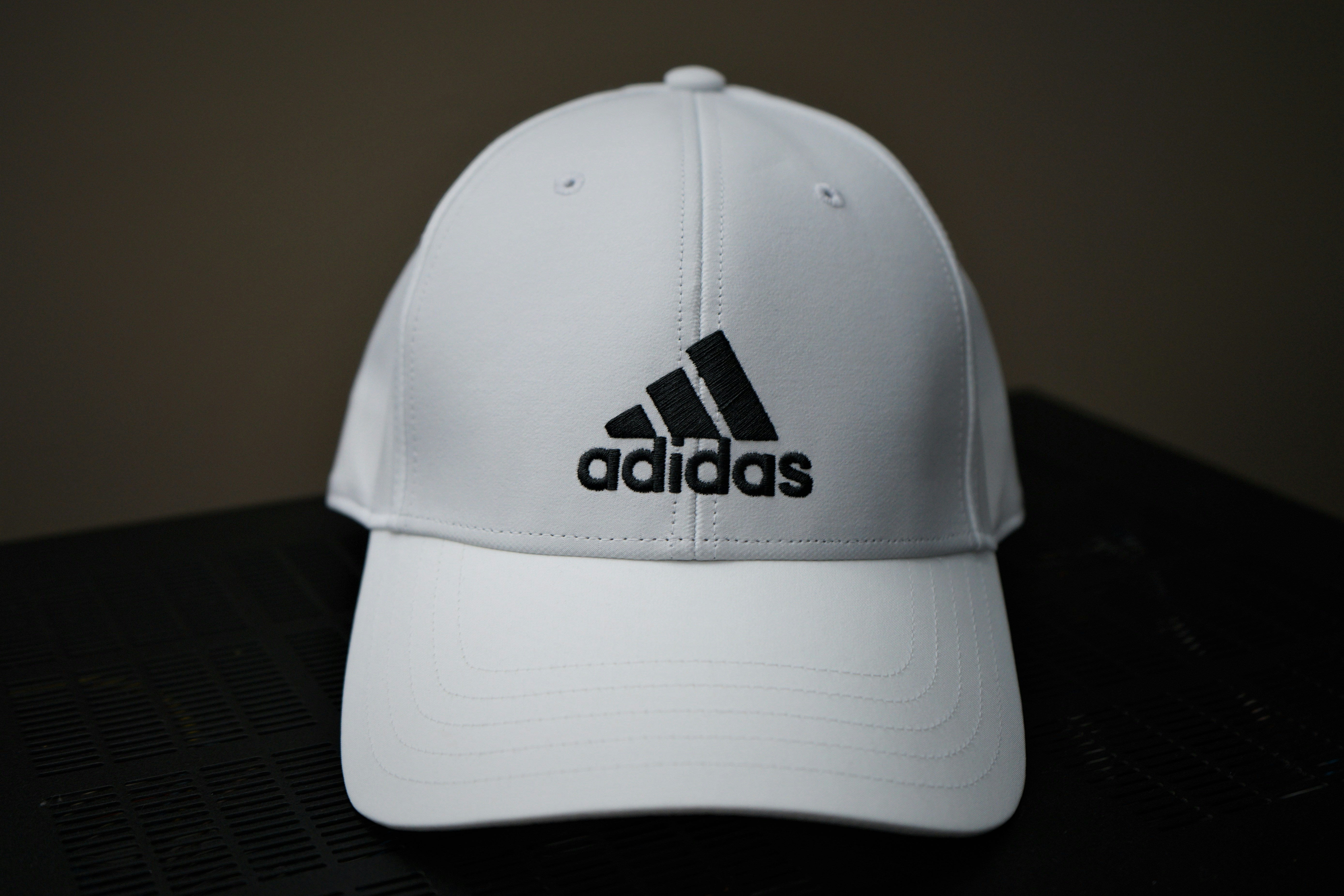 Sleek black athletic cap with embroidered logo on dark background
