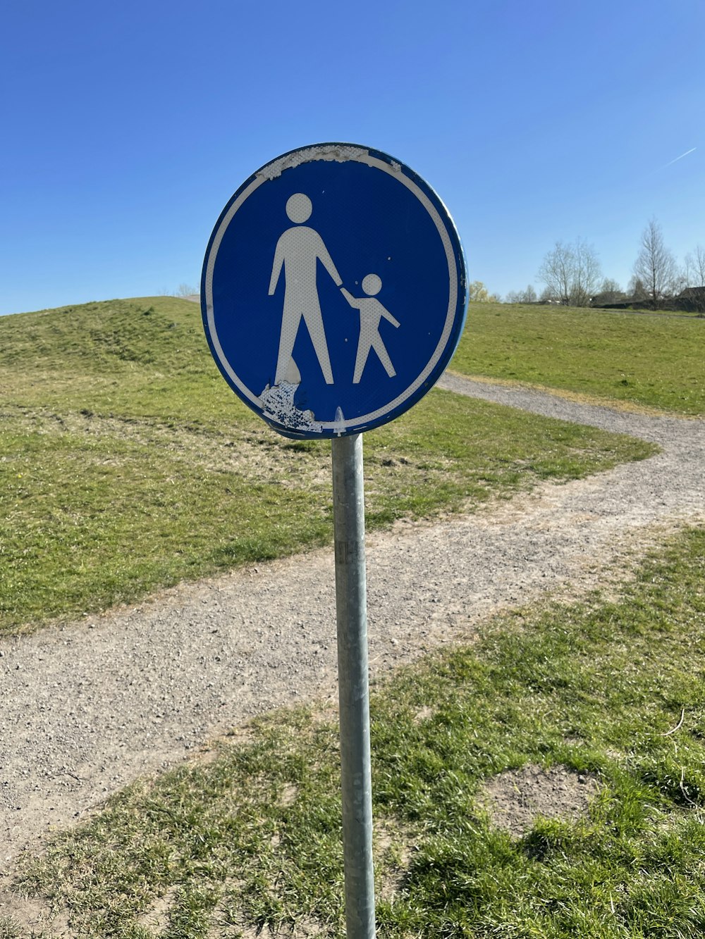 a blue sign with a picture of a person holding a child's hand