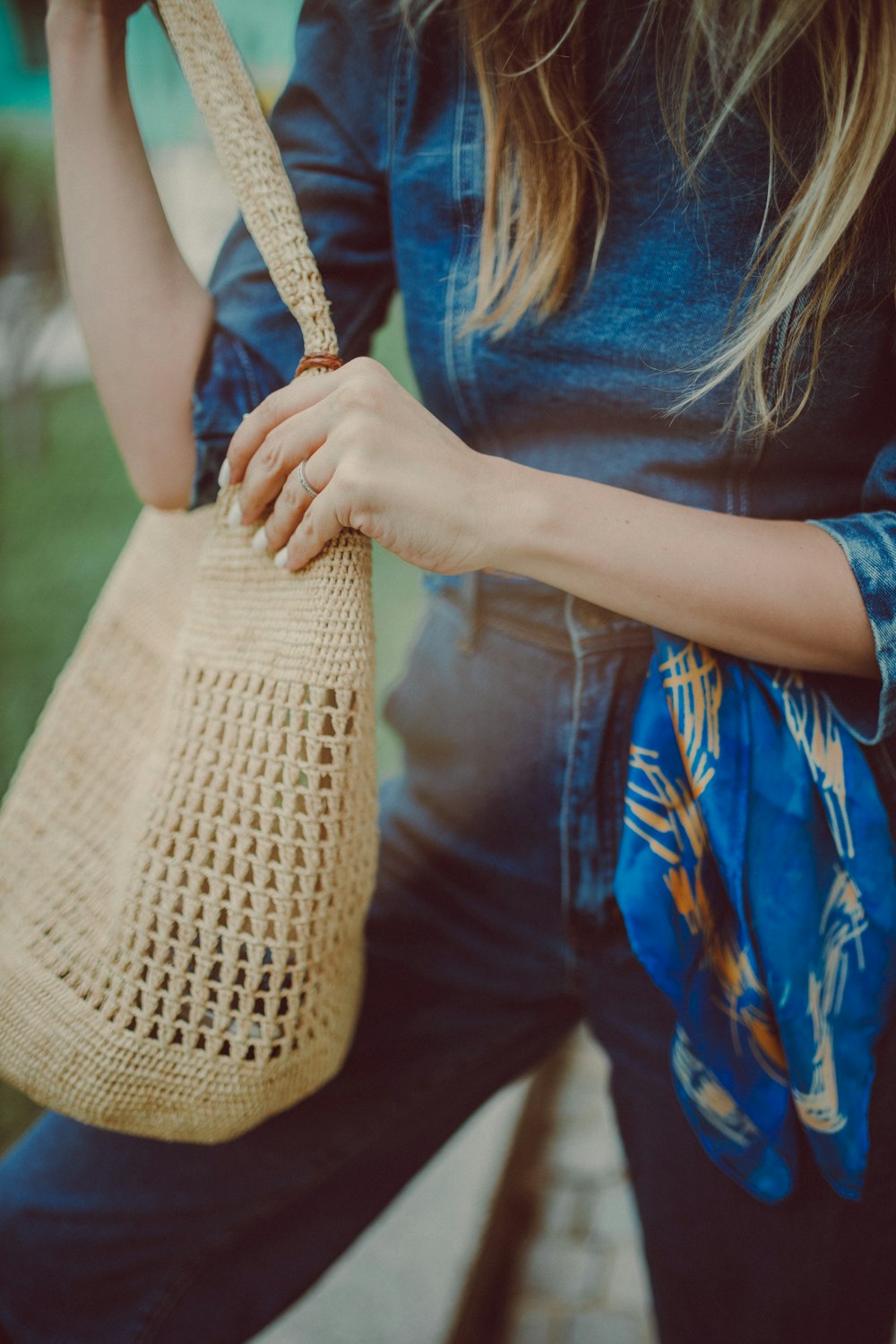 a woman holding a straw bag in her hand