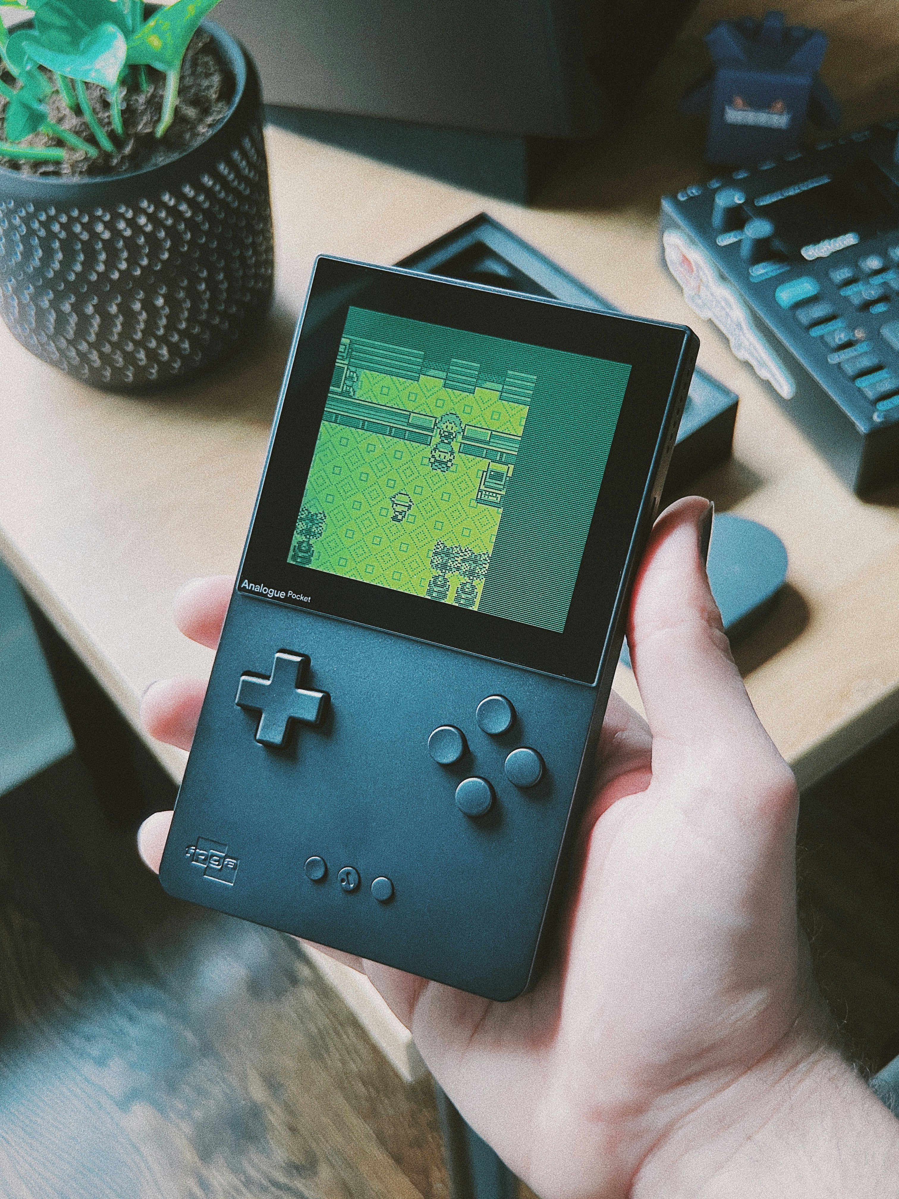 a person holding a gameboy in their hand