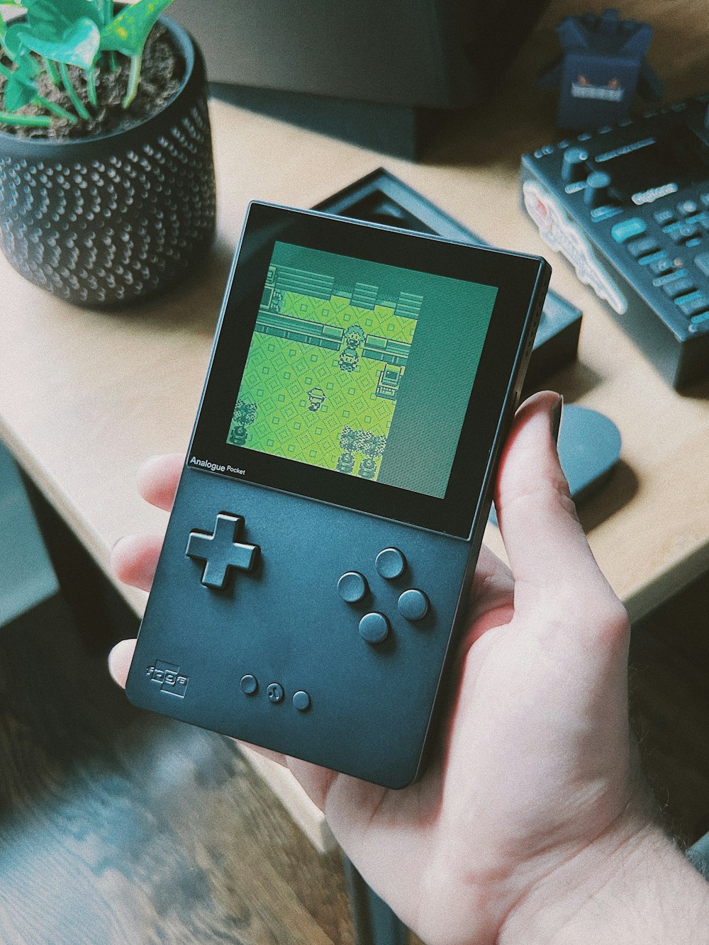 a person holding a gameboy in their hand