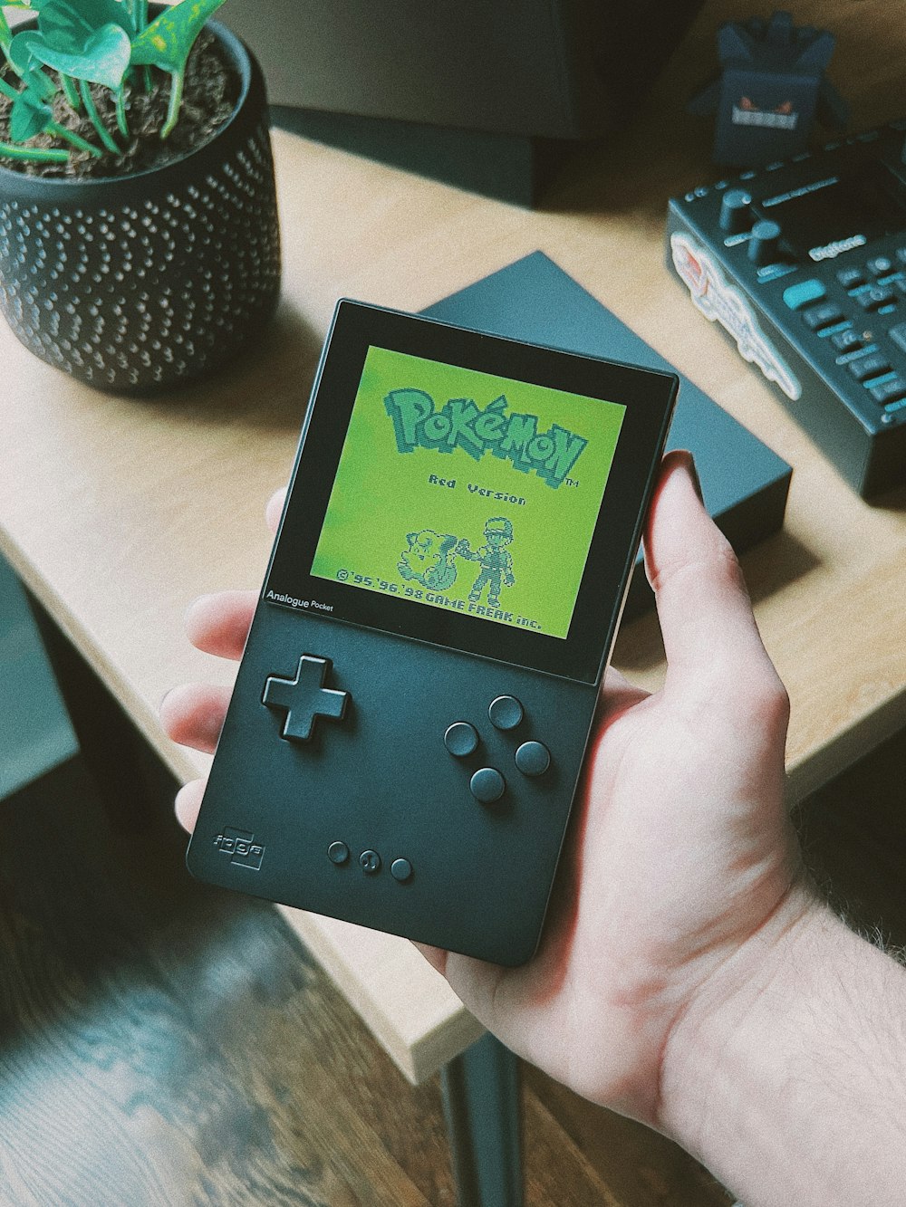a person holding a gameboy in their hand
