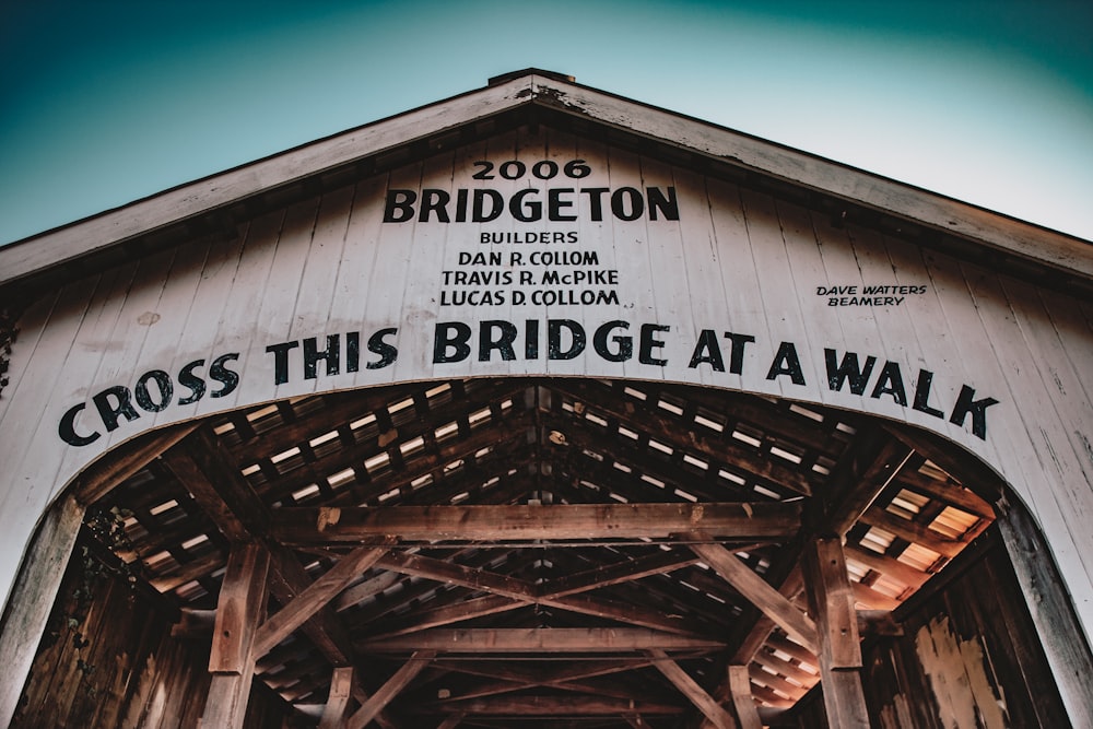 a wooden bridge with a sign that says cross this bridge at a walk