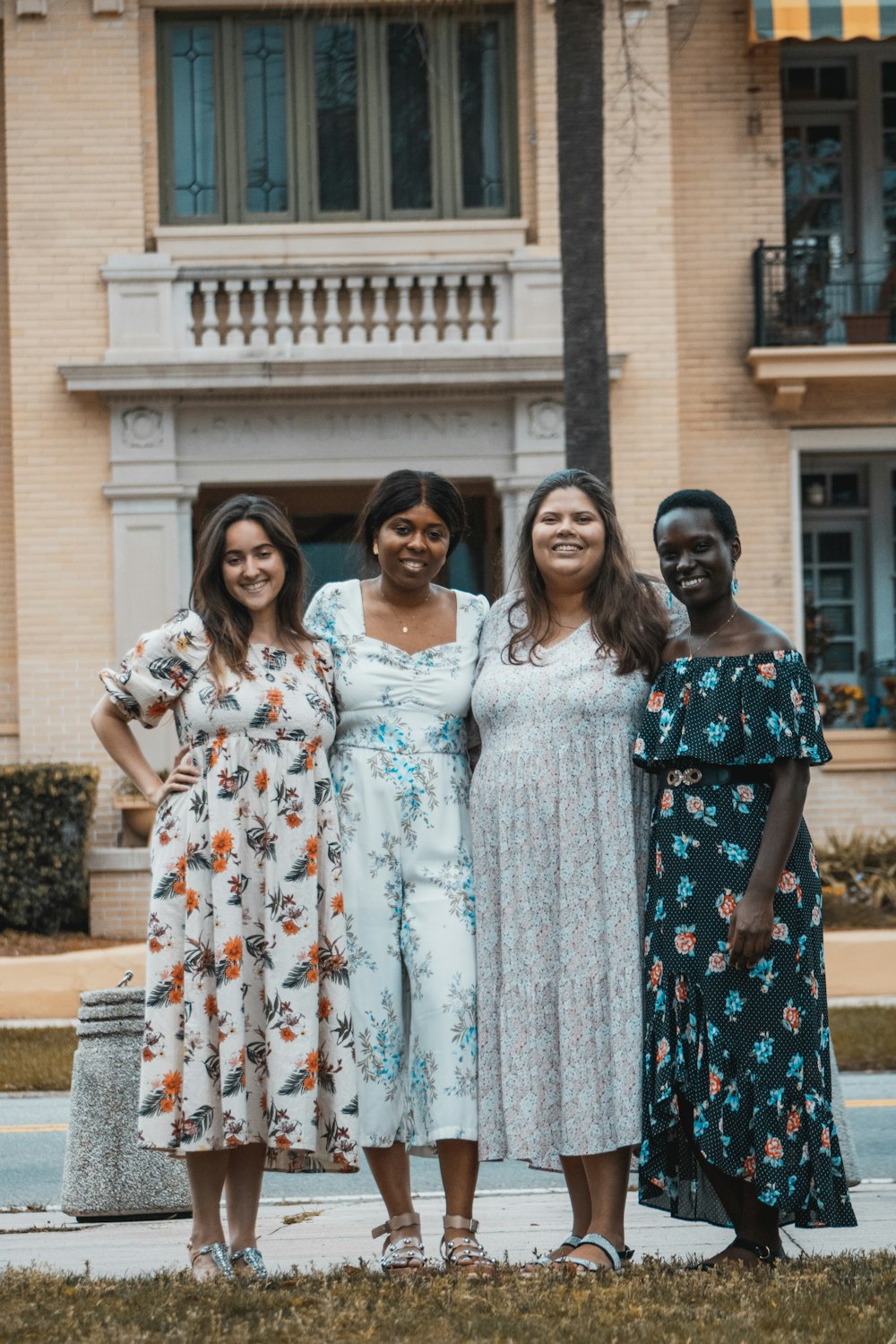 a group of women standing next to each other in front of a building