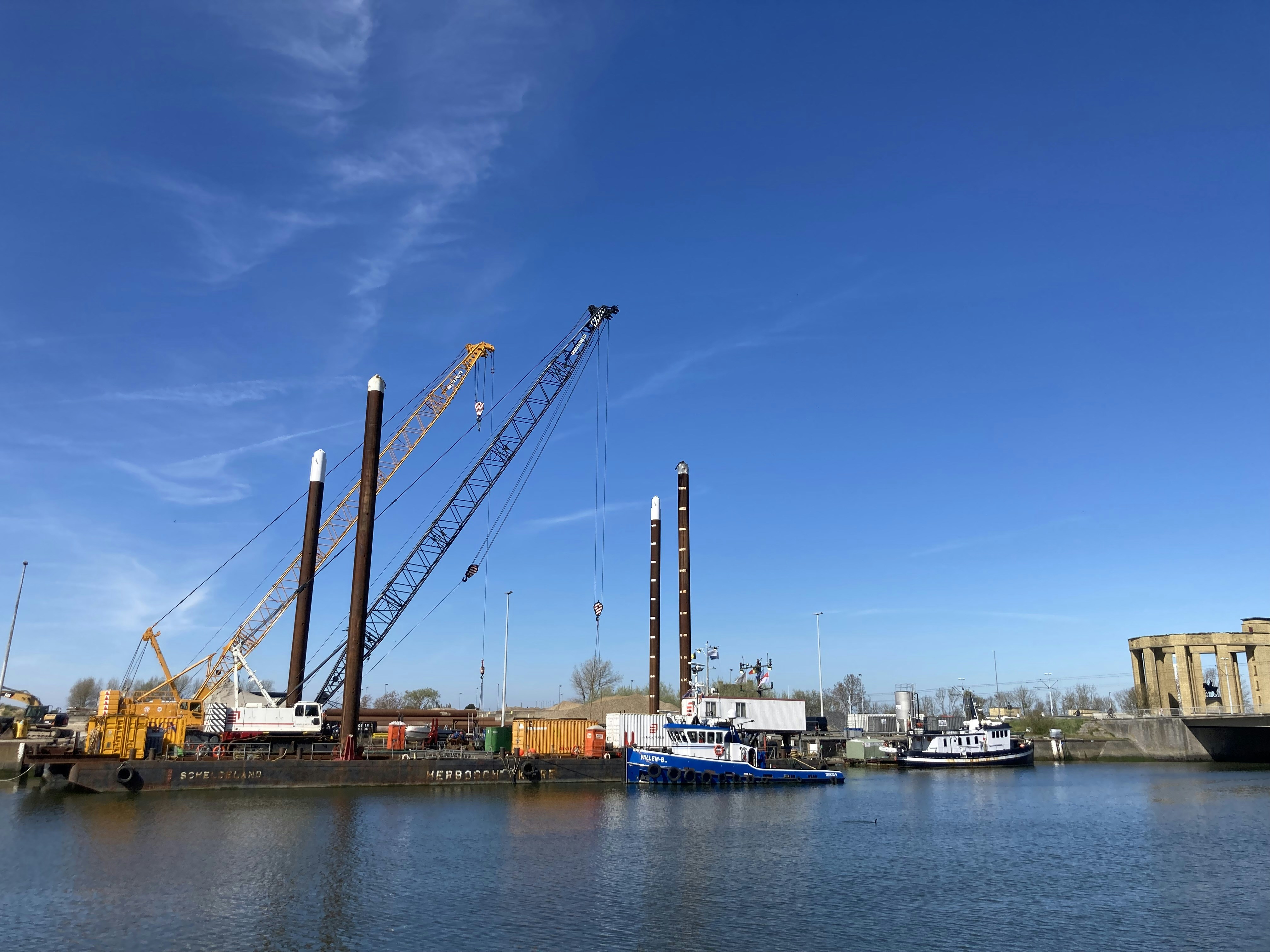 Marine construction barge with a crane operating near a shoreline - marine construction contractor