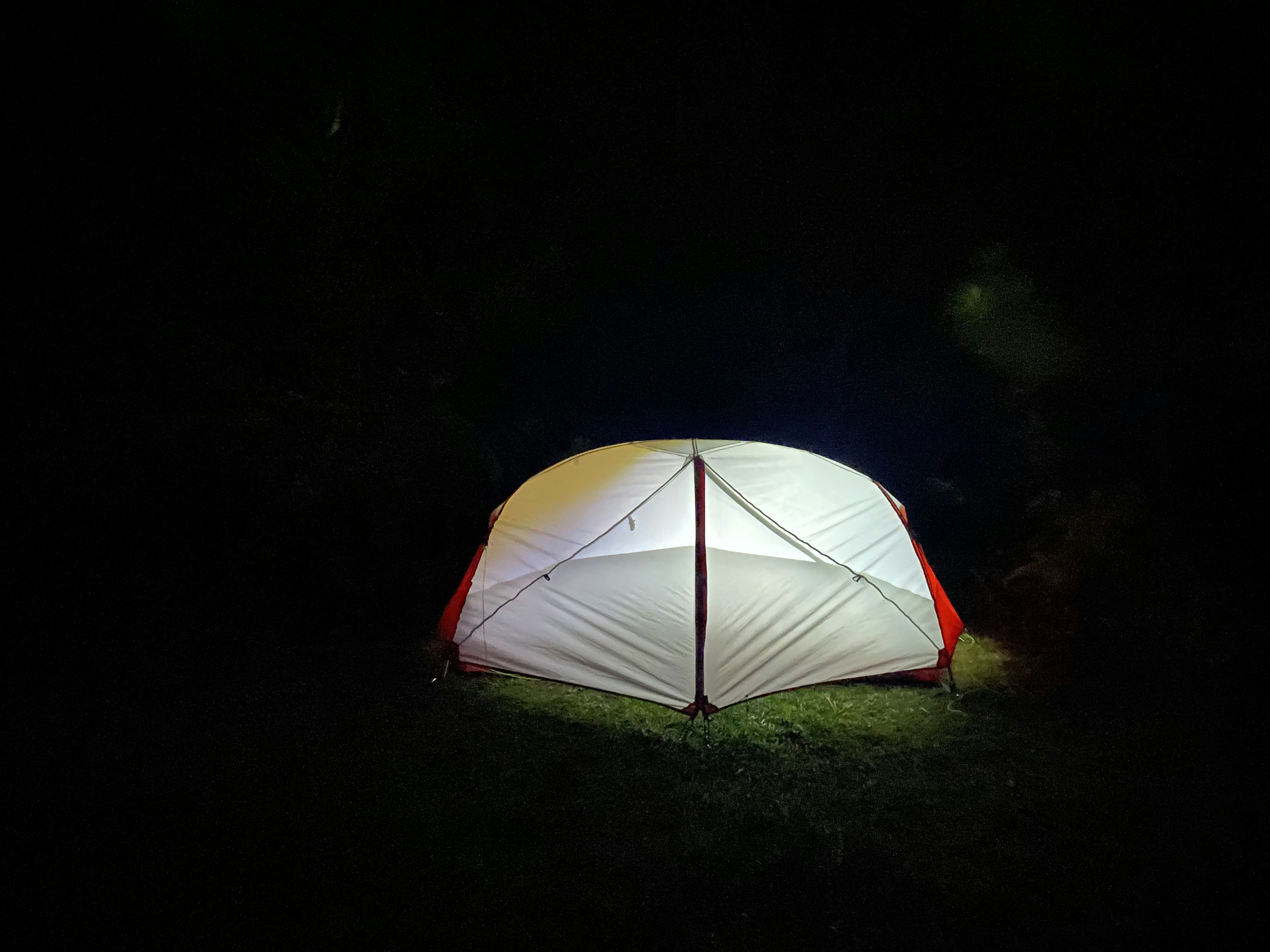 a tent is lit up in the dark